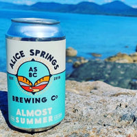 can of alice springs brewing co almost summer pale ale with a lake in the background