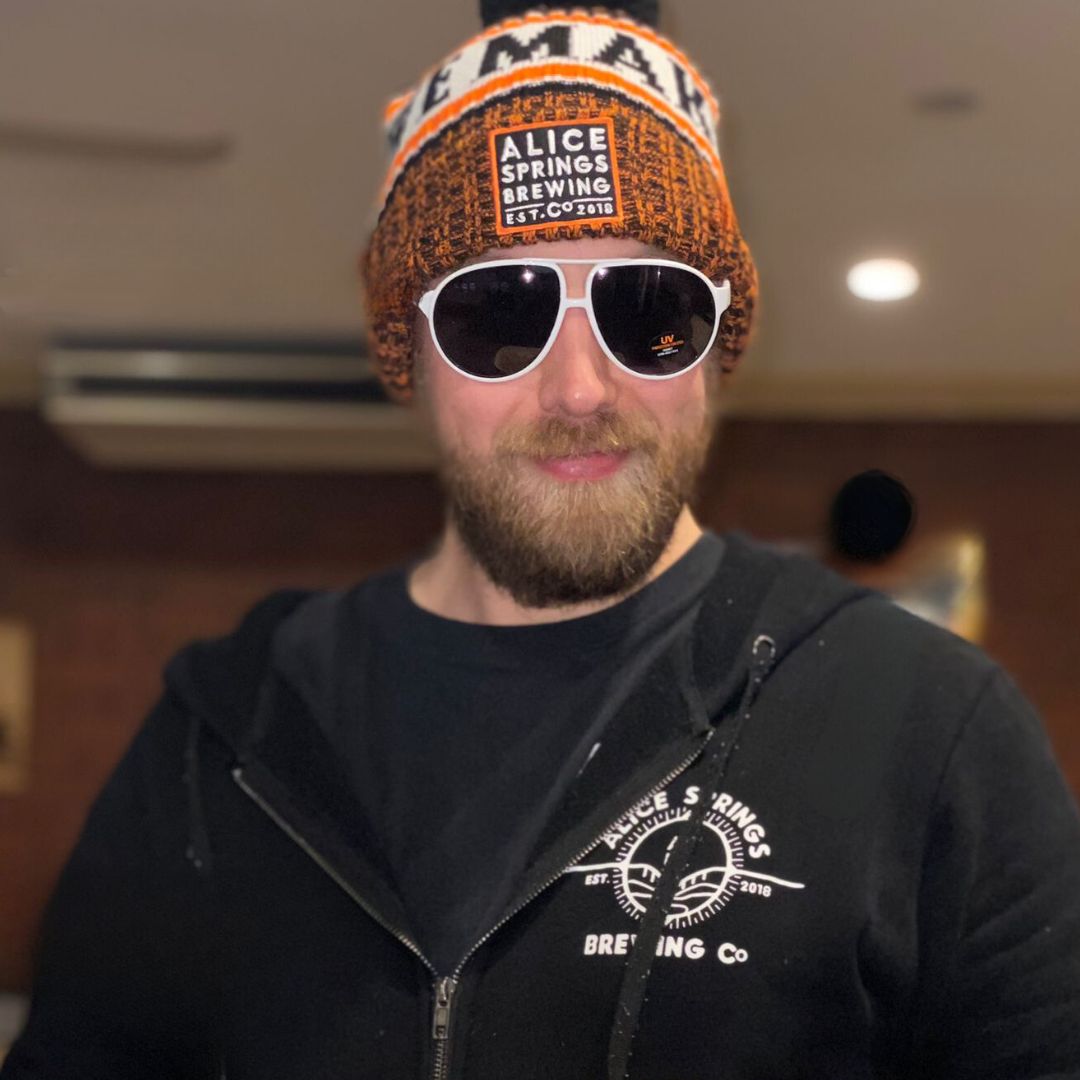 staff at alice springs brewing co wearing the merch collection - beanie, hoodie and sunglasses